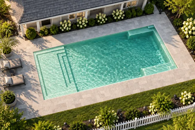 Daytime render of the The Illusion 30 fiberglass pool with cantilever coping and a Beach Sand interior, seen from above at an angle.