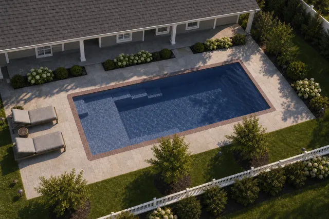 Daytime render of the Enchantment 9.24 fiberglass pool with brick coping and a Ocean Blue interior, seen from above at an angle.