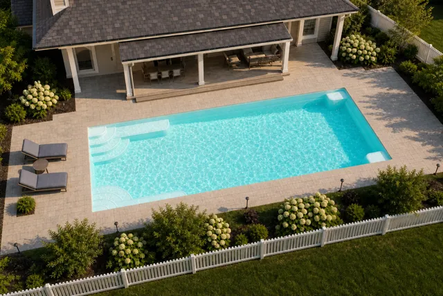 Daytime render of the Goliath 1637 fiberglass pool with cantilever coping and a Arctic Shimmer interior, seen from above at an angle.