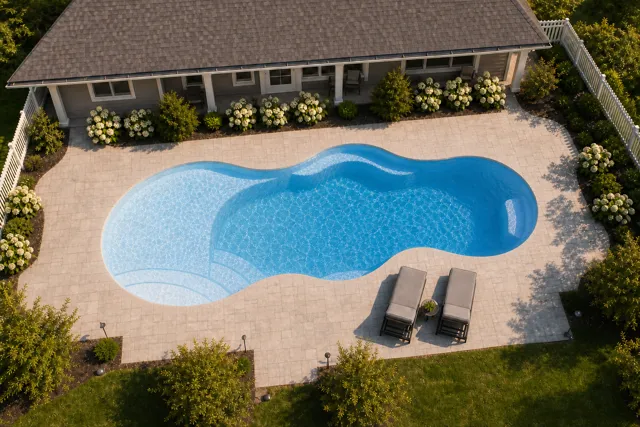 Daytime render of the Axiom 12 fiberglass pool with cantilever coping and a Sapphire Blue interior, seen from above at an angle.