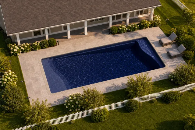 Daytime render of the Barcelona fiberglass pool with stone coping and a Night Sky interior, seen from above at an angle.
