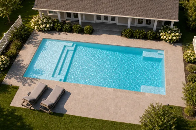 Daytime render of the The Illusion 40 fiberglass pool with stone coping and a Ice Silver interior, seen from above at an angle.