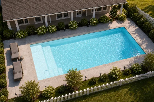 Daytime render of the The Vision 23 fiberglass pool with stone coping and a Ice Silver interior, seen from above at an angle.