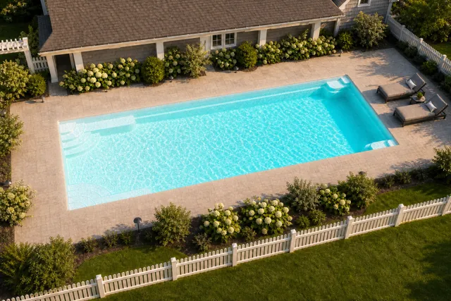 Daytime render of the Goliath 1641 fiberglass pool with cantilever coping and a Arctic Shimmer interior, seen from above at an angle.