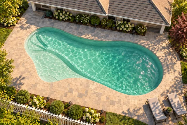Daytime render of the The Inspiration 26 fiberglass pool with cantilever coping and a Beach Sand interior, seen from above at an angle.