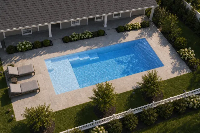 Daytime render of the Enchantment 9.24 fiberglass pool with cantilever coping and a Sapphire Blue interior, seen from above at an angle.