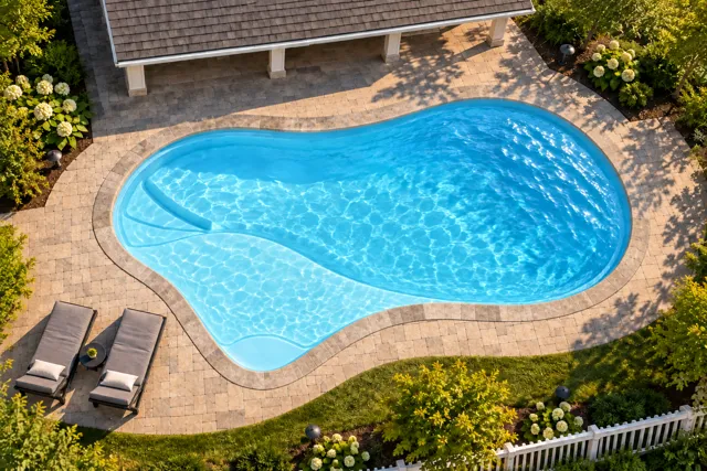 Daytime render of the The Inspiration 23 fiberglass pool with stone coping and a Ice Silver interior, seen from above at an angle.