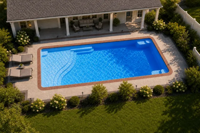 Daytime render of the Aspen 1435 fiberglass pool with brick coping and a California interior, seen from above at an angle.
