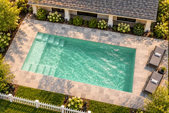 Daytime render of the The Freedom 26 fiberglass pool with cantilever coping and a Beach Sand interior, seen from above at an angle.