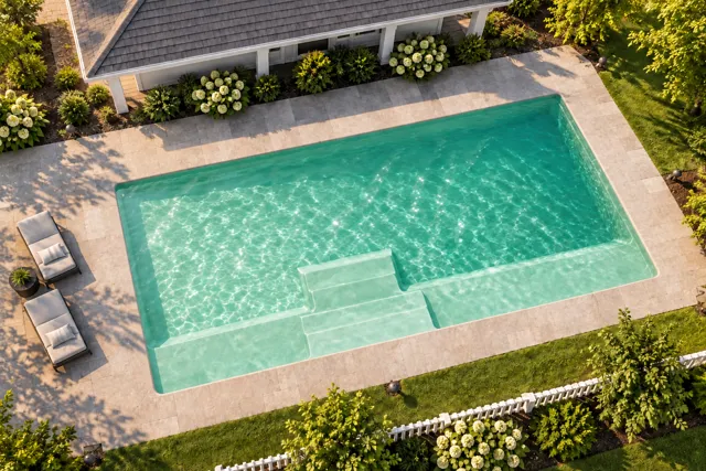 Daytime render of the The Marvelous 30 fiberglass pool with cantilever coping and a Beach Sand interior, seen from above at an angle.