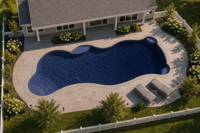 Daytime render of the Synergy fiberglass pool with stone coping and a Night Sky interior, seen from above at an angle.