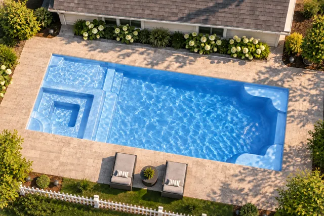 Daytime render of the Astoria 12 fiberglass pool with cantilever coping and a Sapphire Blue interior, seen from above at an angle.