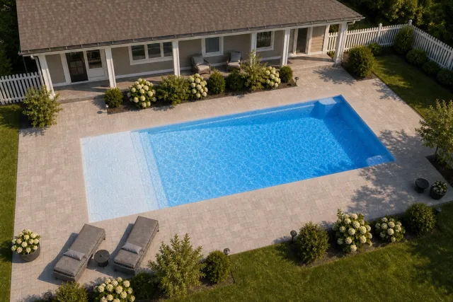 Daytime render of the Corinthian 16 fiberglass pool with cantilever coping and a Sapphire Blue interior, seen from above at an angle.