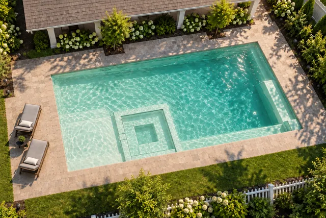Daytime render of the The Exquisite 30 fiberglass pool with cantilever coping and a Beach Sand interior, seen from above at an angle.
