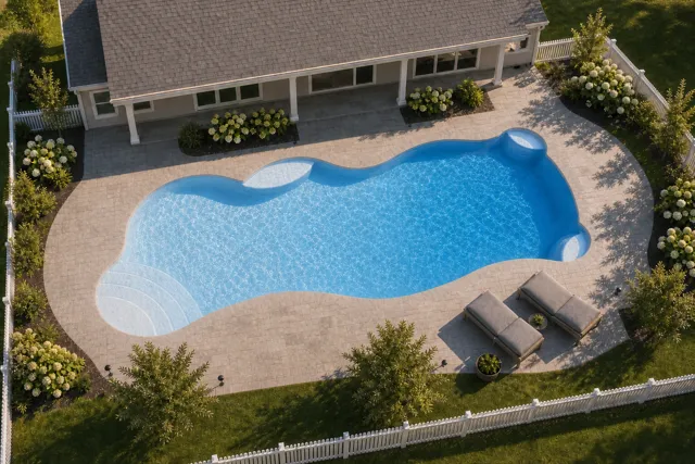 Daytime render of the Synergy fiberglass pool with cantilever coping and a Sapphire Blue interior, seen from above at an angle.