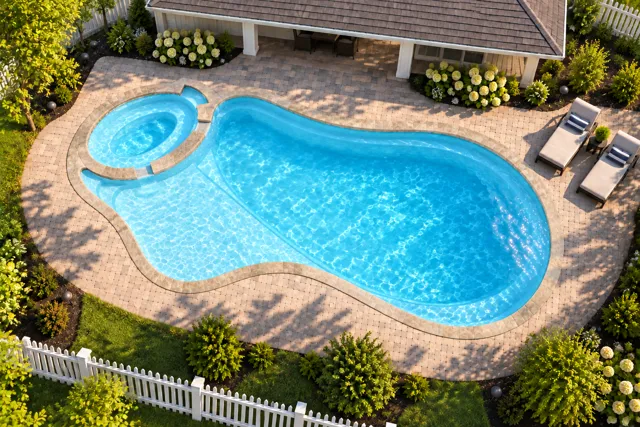 Daytime render of the The Brilliant 40 fiberglass pool with stone coping and a Ice Silver interior, seen from above at an angle.
