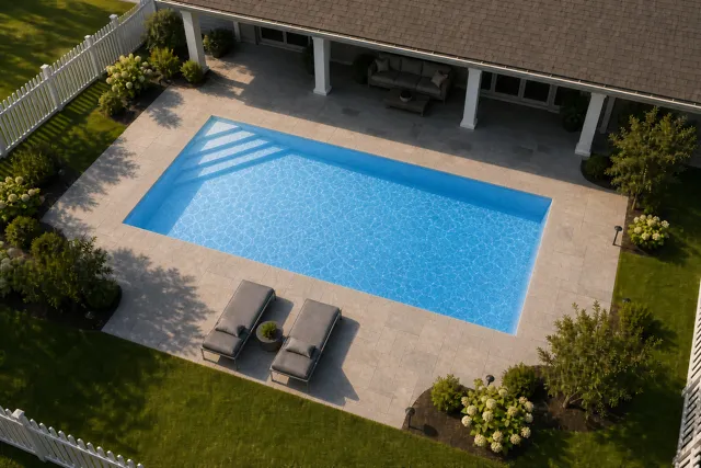 Daytime render of the Delray fiberglass pool with cantilever coping and a Sapphire Blue interior, seen from above at an angle.