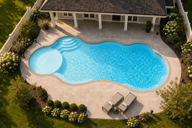 Daytime render of the Wellspring 1640 fiberglass pool with stone coping and a Caribbean Sparkle interior, seen from above at an angle.