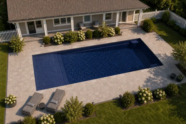 Daytime render of the Corinthian 16 fiberglass pool with stone coping and a Night Sky interior, seen from above at an angle.