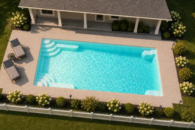Daytime render of the Goliath 1633 fiberglass pool with cantilever coping and a Arctic Shimmer interior, seen from above at an angle.
